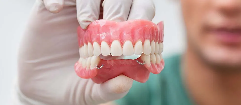 Dentist holding dentures