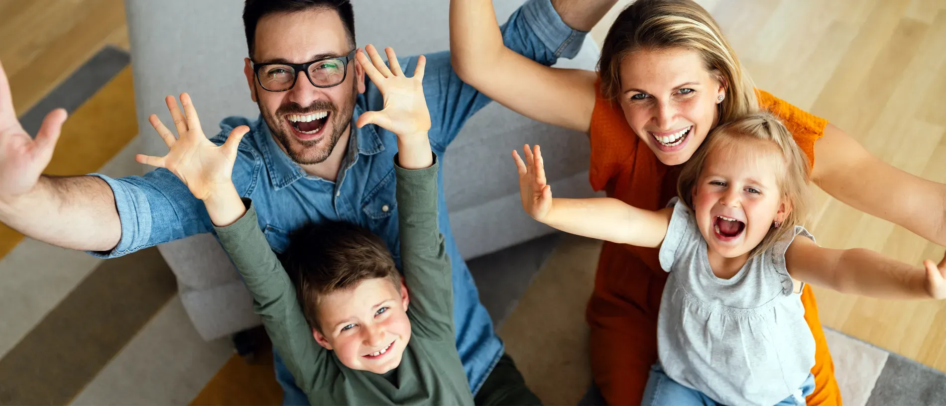 Smiling family with arms extended towards camera